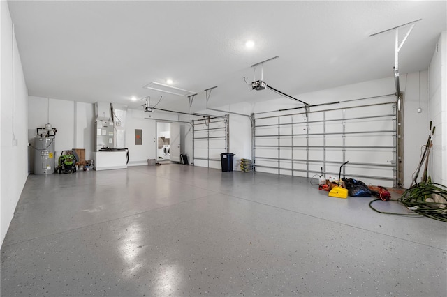 garage with a garage door opener, electric water heater, and electric panel