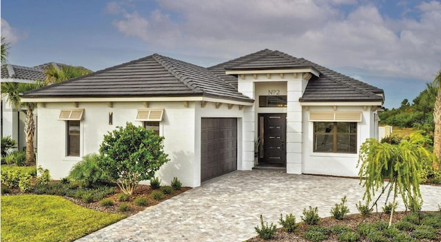 view of front facade with a garage, decorative driveway, and stucco siding