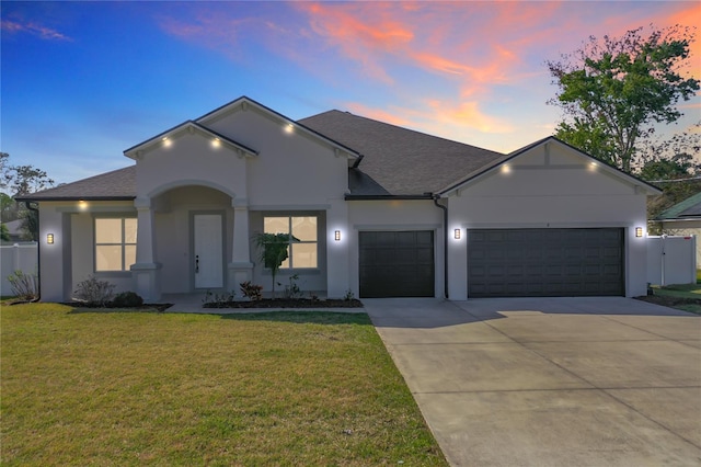 single story home with stucco siding, driveway, a lawn, and an attached garage