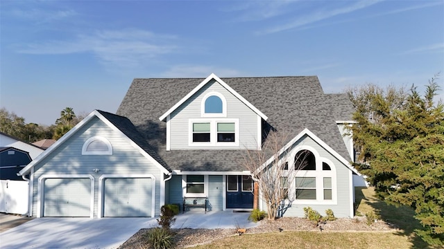 traditional-style house with concrete driveway, roof with shingles, an attached garage, and covered porch