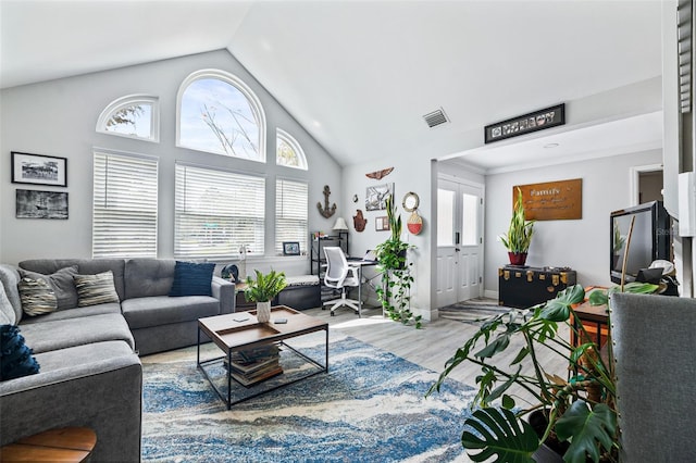 living room featuring high vaulted ceiling, visible vents, and wood finished floors