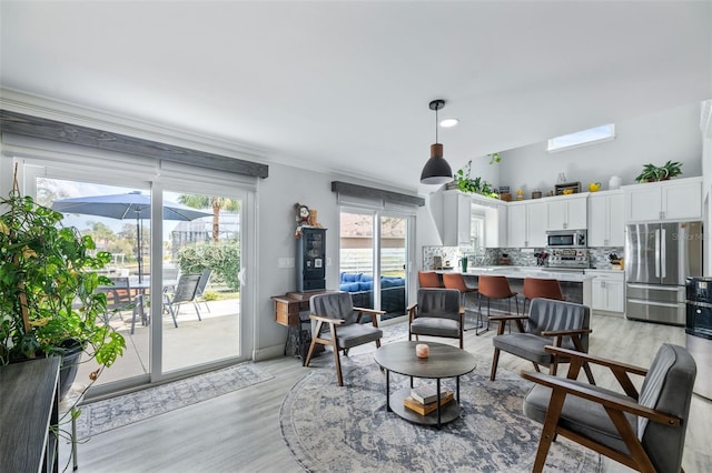 living room with light wood-type flooring and crown molding