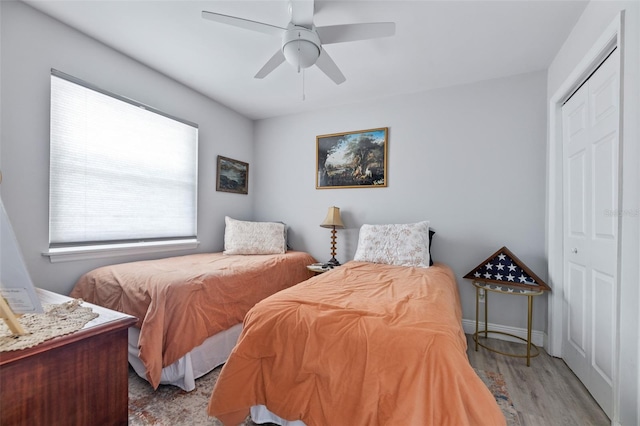 bedroom featuring a closet, ceiling fan, baseboards, and wood finished floors