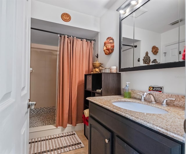 bathroom featuring vanity, visible vents, a tile shower, and tile patterned floors