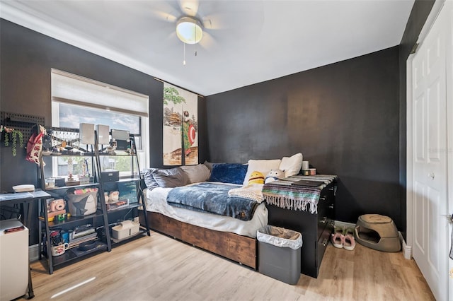 bedroom featuring ceiling fan, baseboards, and wood finished floors