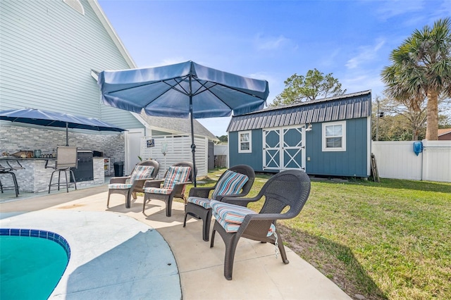 view of patio featuring a fenced backyard, a storage unit, a fenced in pool, and an outbuilding