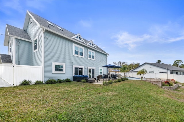 rear view of property featuring a garden, a yard, a fenced backyard, and a patio