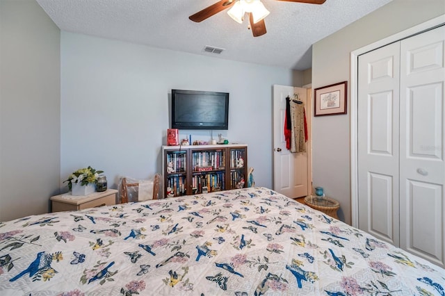 bedroom featuring a textured ceiling, a closet, visible vents, and a ceiling fan