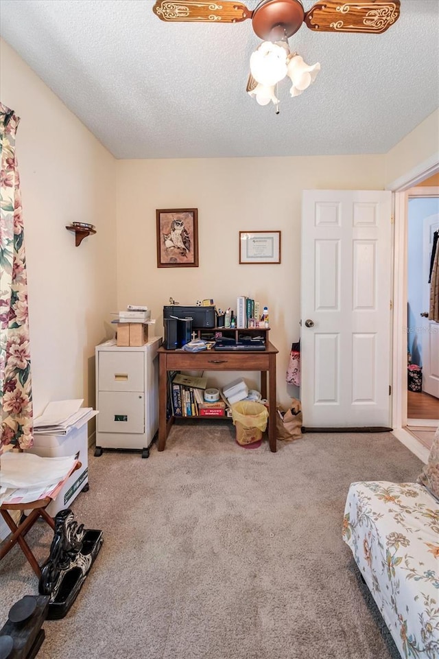 office space with a ceiling fan, carpet flooring, and a textured ceiling