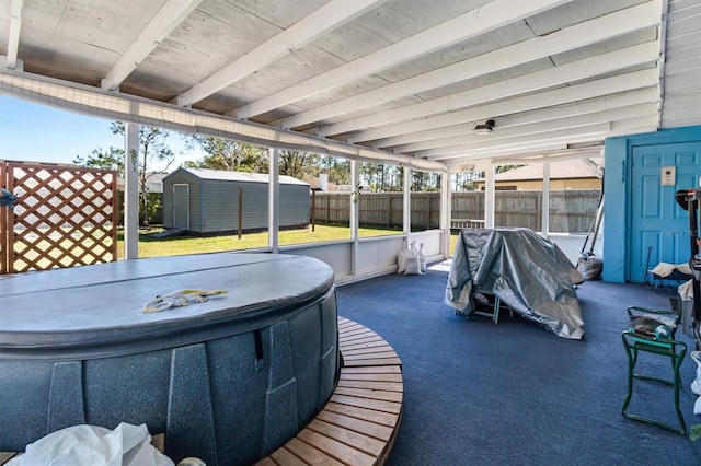 view of patio / terrace featuring a shed, fence, and an outbuilding