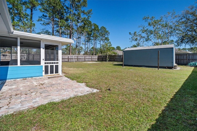 view of yard with a patio area, a fenced backyard, and a sunroom