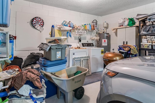 garage with water heater, separate washer and dryer, and concrete block wall