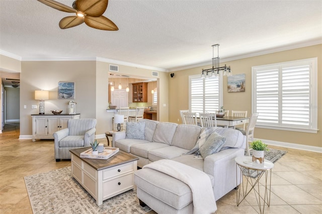 living room with a textured ceiling, light tile patterned floors, visible vents, baseboards, and crown molding