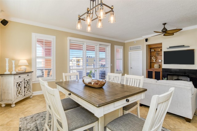 dining area featuring visible vents, ornamental molding, a textured ceiling, and ceiling fan with notable chandelier