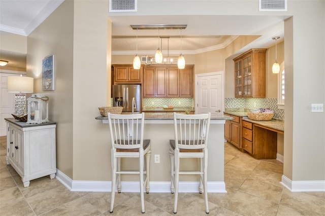 kitchen featuring brown cabinetry, visible vents, and stainless steel fridge with ice dispenser