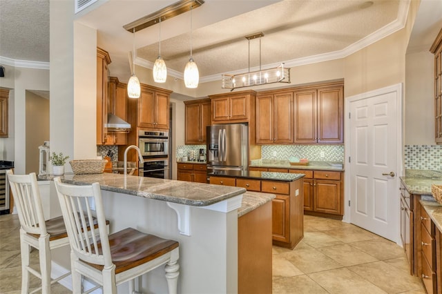 kitchen with a peninsula, appliances with stainless steel finishes, wall chimney range hood, and crown molding