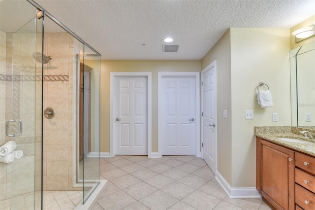 full bathroom with a stall shower, tile patterned flooring, visible vents, and vanity