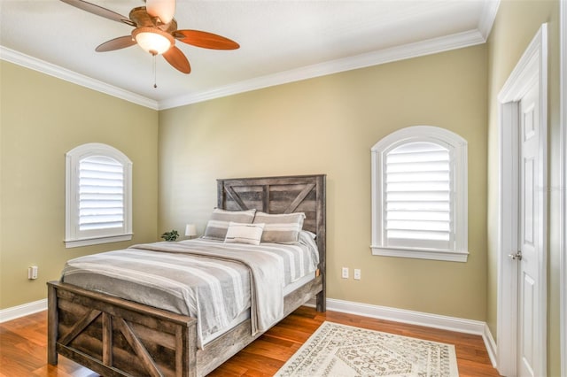 bedroom featuring crown molding, multiple windows, wood finished floors, and baseboards