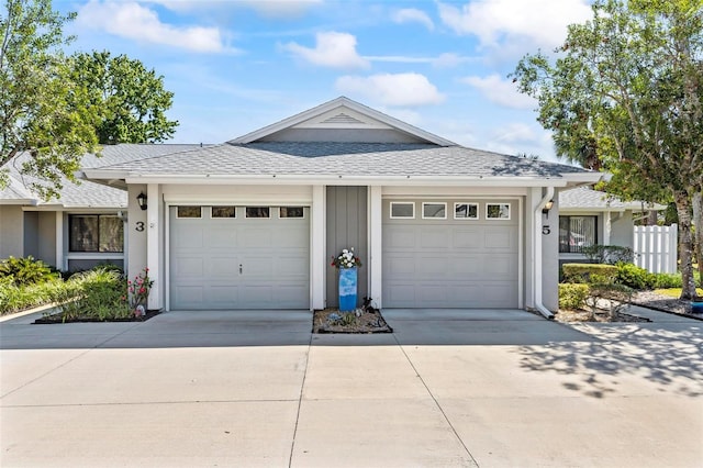 view of front of home featuring concrete driveway, a garage, and roof with shingles