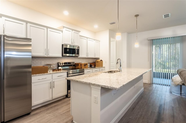 6 Zamia Pl, Palm Coast, FL 32164 - kitchen featuring a sink, backsplash, wood finished floors, stainless steel appliances, and white cabinets
