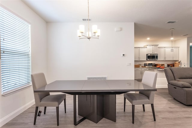 6 Zamia Pl, Palm Coast, FL 32164 - dining area with light wood finished floors, visible vents, baseboards, an inviting chandelier, and plenty of natural light