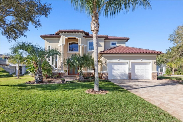 mediterranean / spanish-style home featuring a garage, a front yard, decorative driveway, and stucco siding