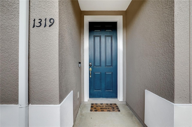 entrance to property with stucco siding