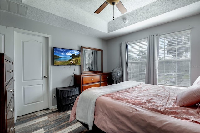 bedroom with visible vents, ceiling fan, a textured ceiling, and wood finished floors