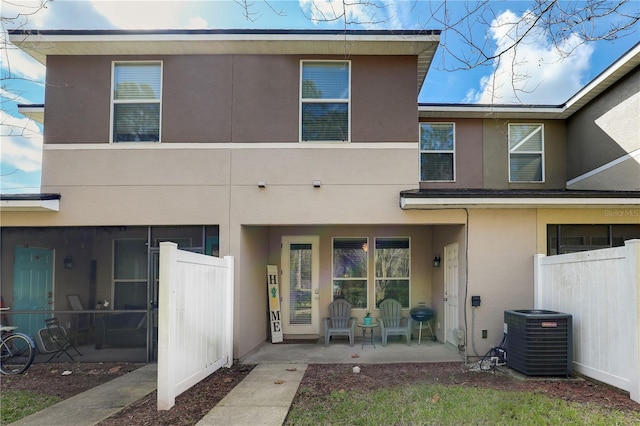 exterior space featuring fence, central AC, and stucco siding