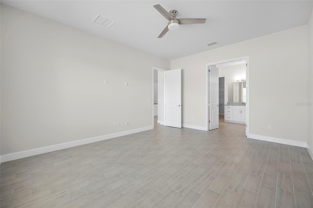 unfurnished bedroom with light wood finished floors, visible vents, ensuite bathroom, and baseboards