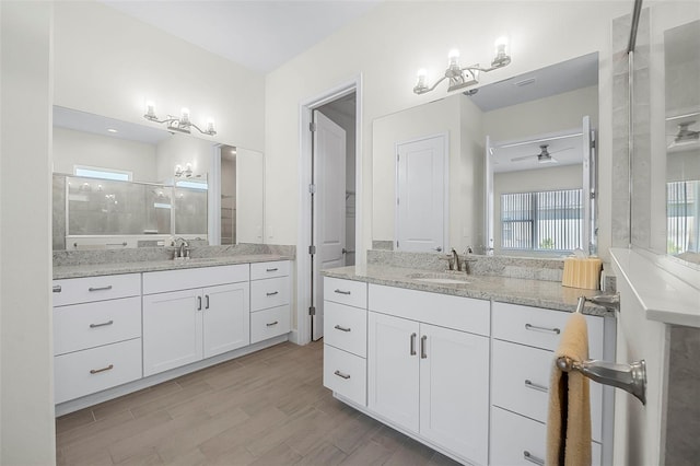 bathroom featuring a sink, two vanities, and wood finished floors