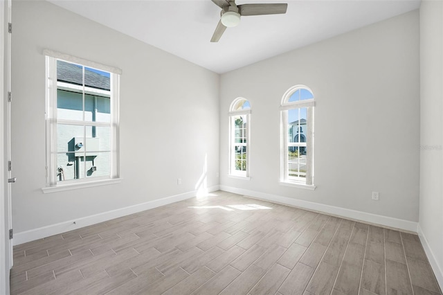 unfurnished room with baseboards, light wood-style floors, and a ceiling fan