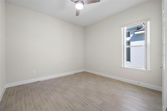 unfurnished room with a ceiling fan, baseboards, and light wood-type flooring