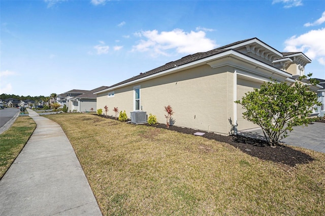 view of property exterior with a residential view, central AC unit, stucco siding, a lawn, and an attached garage