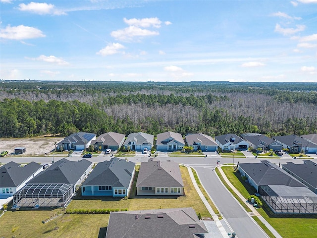 drone / aerial view with a wooded view and a residential view