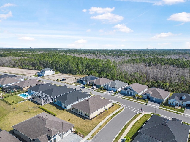 drone / aerial view featuring a residential view and a wooded view