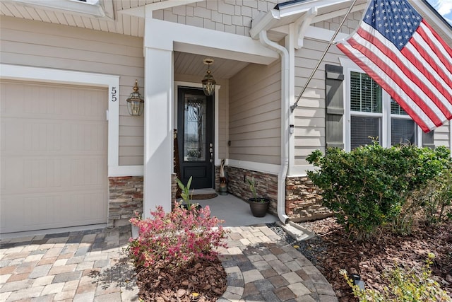 property entrance featuring stone siding and an attached garage