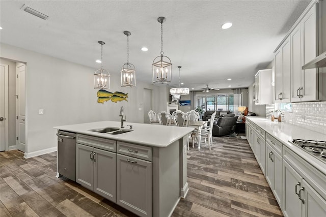 kitchen with dark wood-style floors, visible vents, a sink, and stainless steel dishwasher