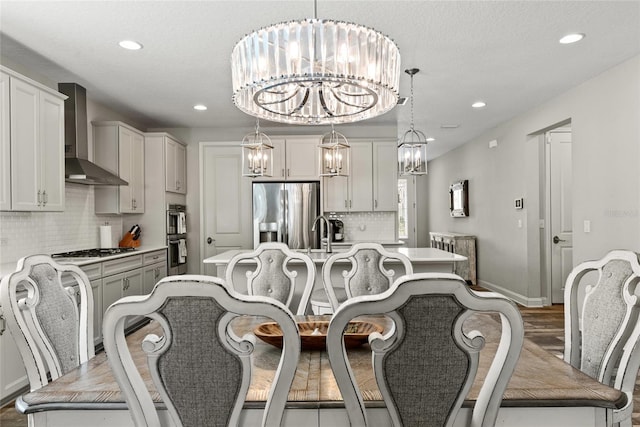 dining area featuring baseboards, recessed lighting, wood finished floors, and a notable chandelier