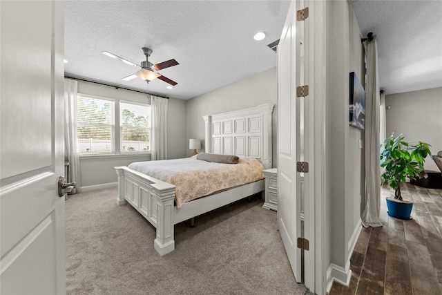 bedroom featuring a textured ceiling, ceiling fan, carpet floors, visible vents, and baseboards