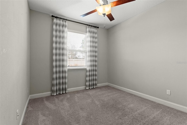 unfurnished room with carpet floors, a ceiling fan, and baseboards