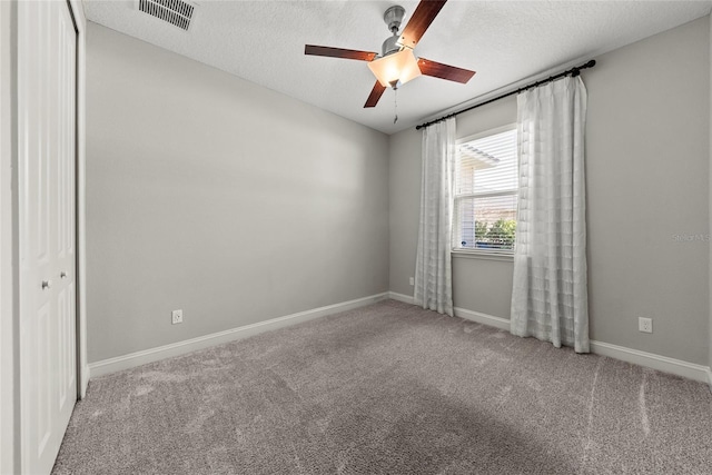 unfurnished room featuring carpet floors, baseboards, visible vents, and a textured ceiling