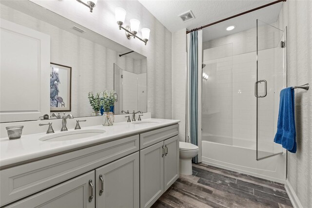 bathroom featuring visible vents, a sink, toilet, and wood finished floors