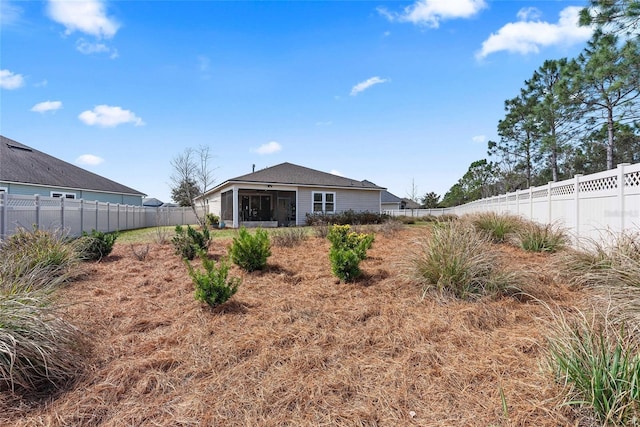 back of property featuring a fenced backyard and a sunroom