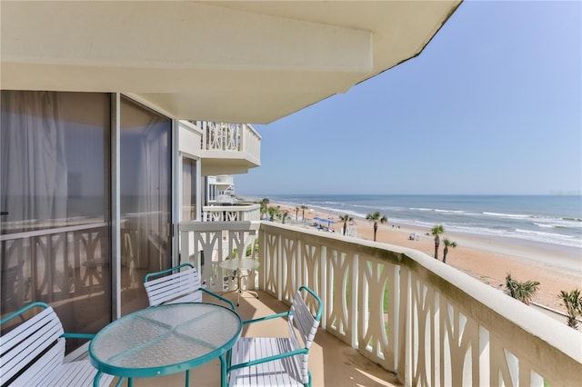 balcony featuring a beach view and a water view