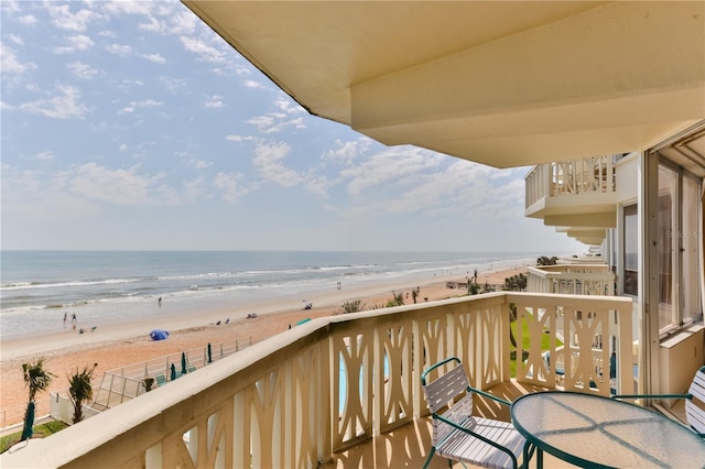 balcony featuring a view of the beach and a water view