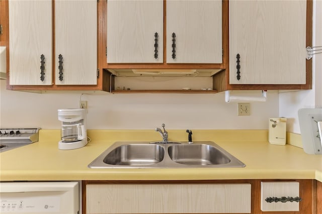 kitchen with light countertops, a sink, and dishwashing machine