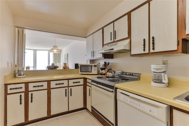 kitchen with pendant lighting, light countertops, a sink, white appliances, and under cabinet range hood