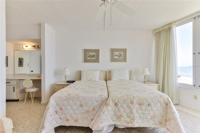 bedroom with light carpet, ceiling fan, and a textured ceiling