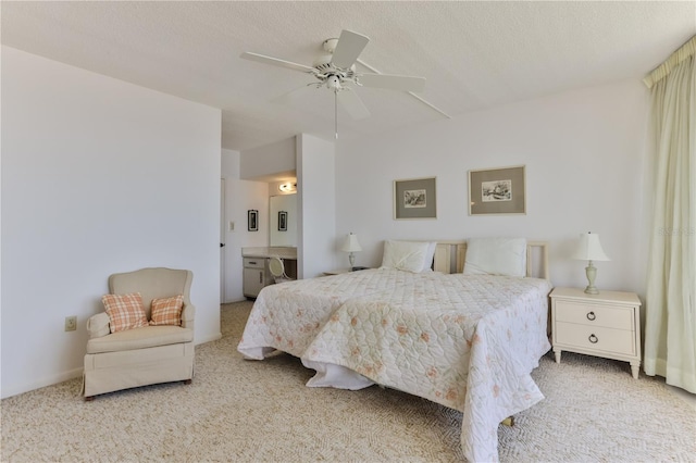 bedroom with ceiling fan, a textured ceiling, carpet flooring, and ensuite bathroom